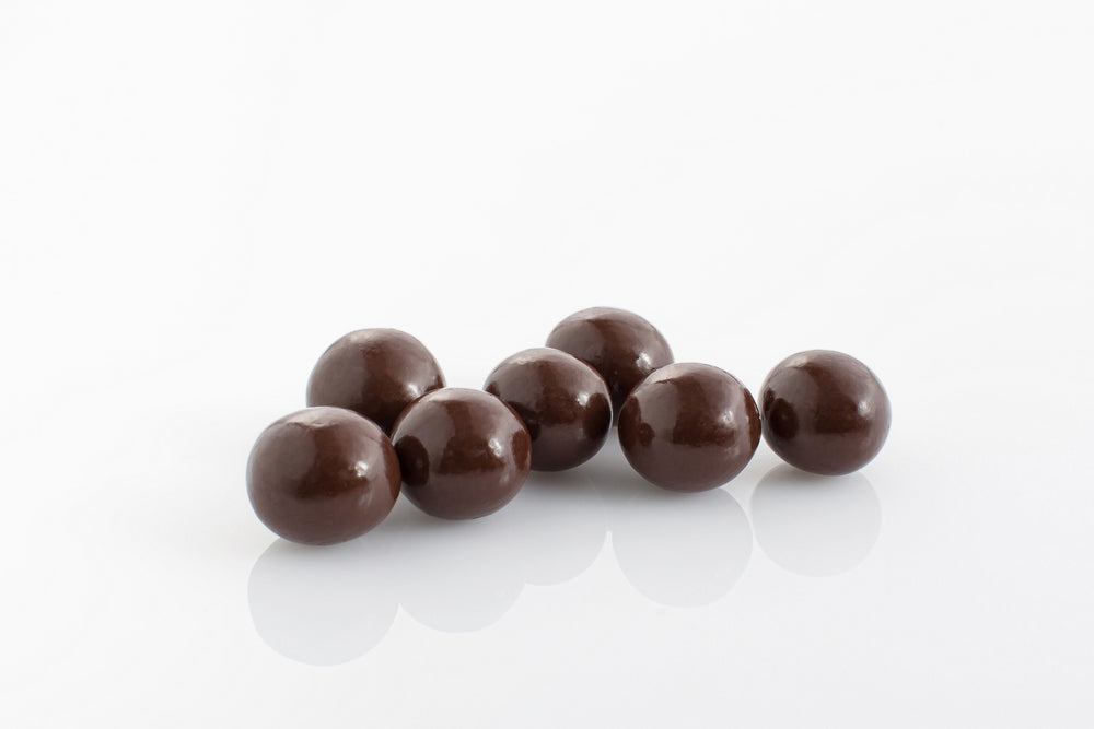 Group of Malt Balls coated in couverture dark chocolate