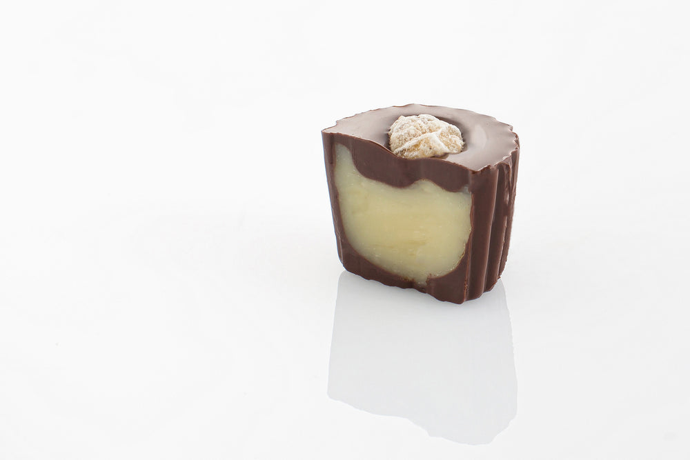 Single Dark Ginger Truffle Cut in half to reveal a soft truffle centre infused with ginger flavour