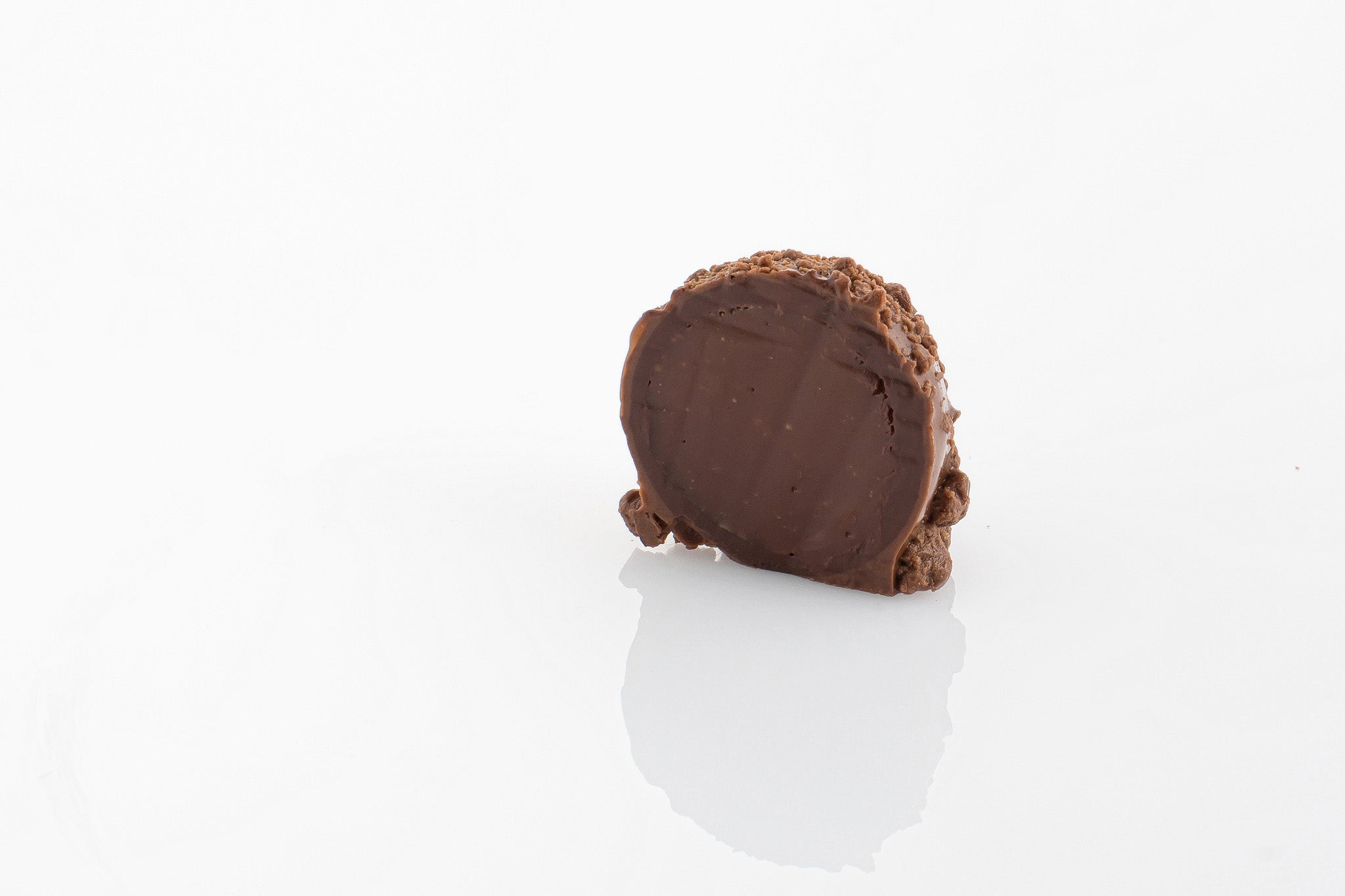 Single Grand Marnier Truffle Cut in half to reveal a smooth orange grand marnier ganache centre