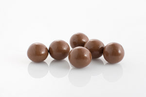 Group of whole macadamias coated in creamy 27% cocoa milk couverture chocolate from Share Chocolates