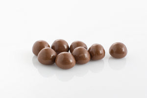 Group of chewy raspberries encased in smooth milk couverture chocolate from Share Chocolates