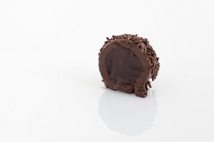 Single Rum Ball cut in half to reveal a creamy dark couverture chocolate and rum infused truffle filling