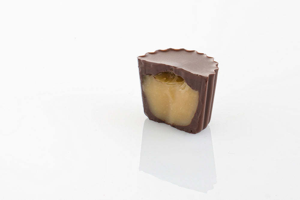 Single Dark Salted Caramel Truffle Cut in half to reveal a thick caramel cream filling