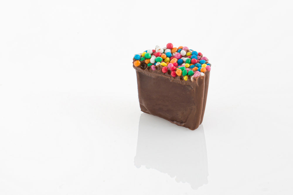 Single Speckle Cup cut in half to reveal a smooth milk couverture chocolate truffle centre